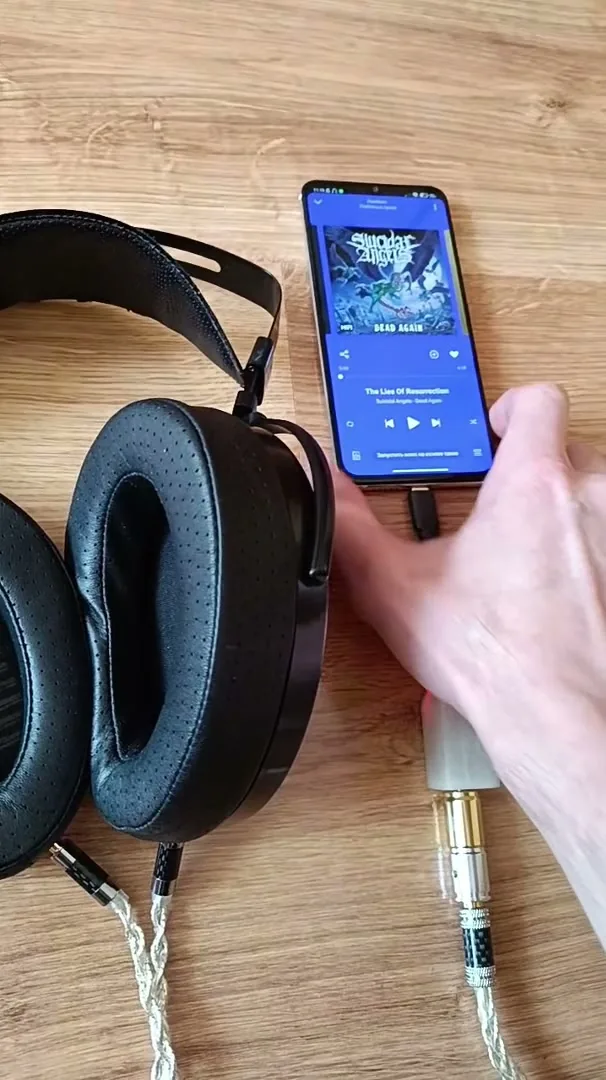 USB-ЦАП Слон в белом корпусе с красным индикатором подключён к телефону, от него кабель идёт к планарным наушникам Hifiman